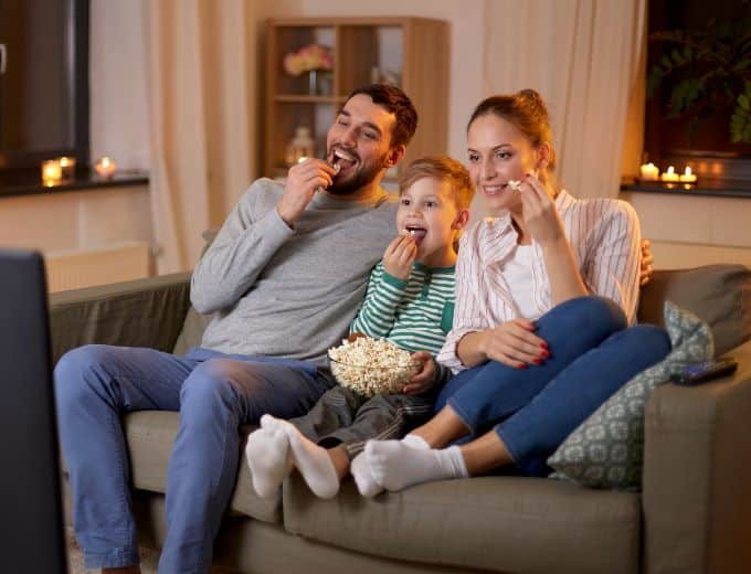 family watching a movie eating popcorn