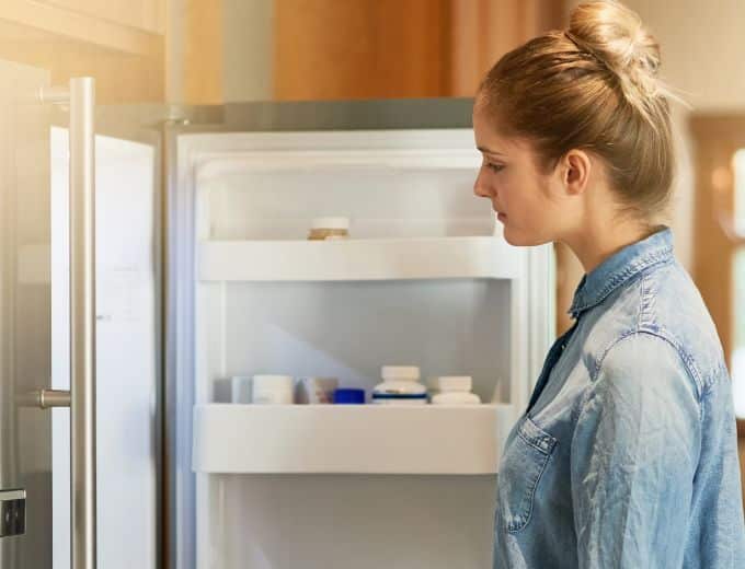 woman looking into refrigerator